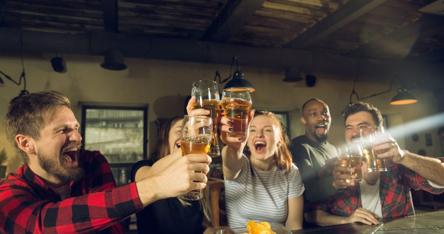 Freunde die in der Bar die Gläser heben und sich freuen. Trinkkultur.