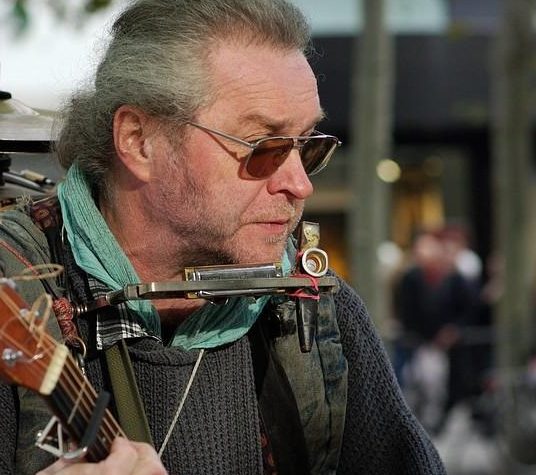 Ramblin Conrad trägt Sonnenbrille und spielt Gitarre