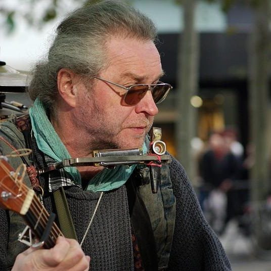Ramblin Conrad trägt Sonnenbrille und spielt Gitarre